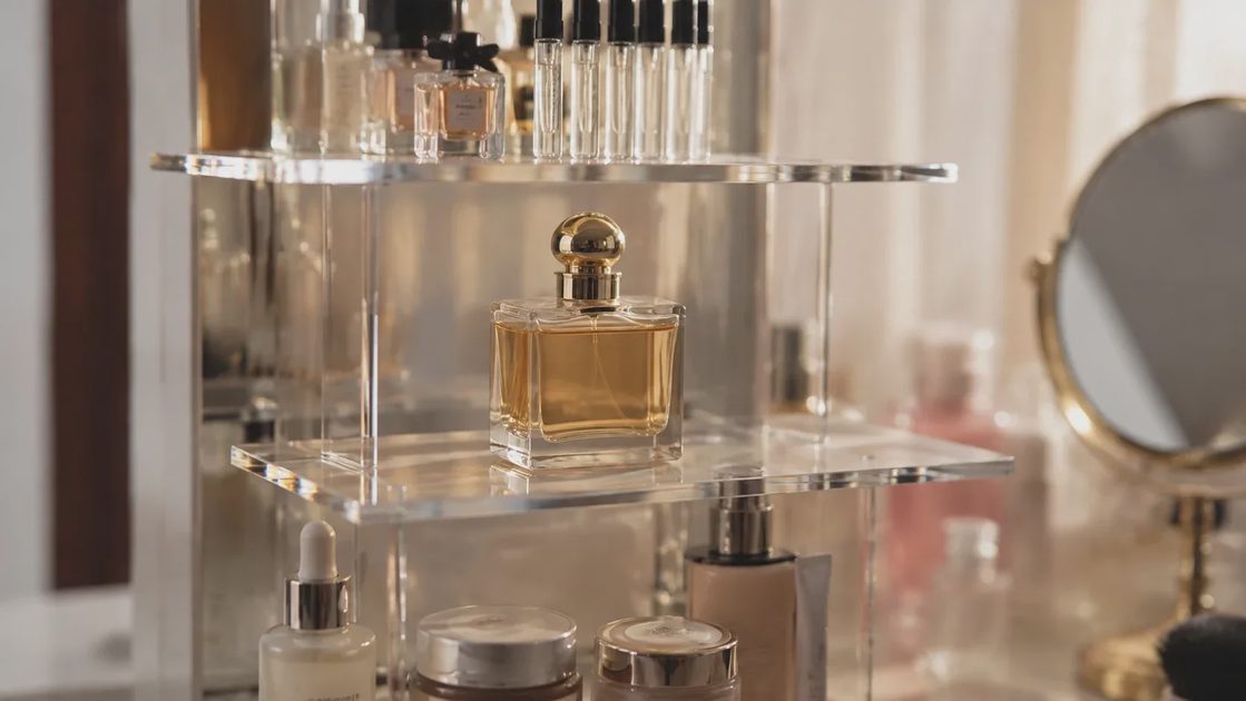 Close-up of four-tier acrylic display risers holding perfume and skincare